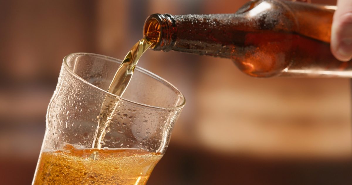 Beer,Is,Poured,From,Dark,Brown,Bottle,Into,Beer,Glass.